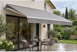Toile grise unie de store banne avec gouttes d’eau, déployée au-dessus d’une terrasse
