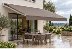 Toile taupe unie de store banne avec gouttes d’eau, déployée au-dessus d’une terrasse avec table et chaises.