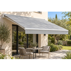 Toile microperforée grise de store banne, déployée au-dessus d’une terrasse avec table et chaises
