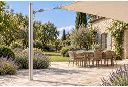 Mât aluminium T4 Ø 131 mm avec pontet réglable et système de tension sur une terrasse en pierre dans un jardin.